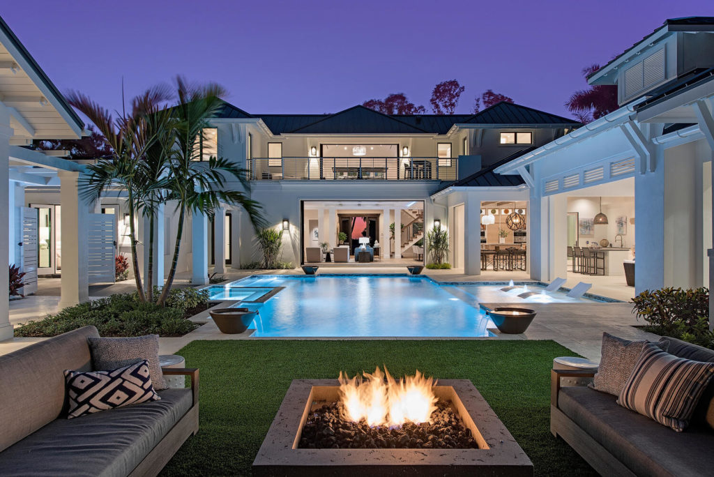 Custom home in Naples Florida with firepit and pool view at night