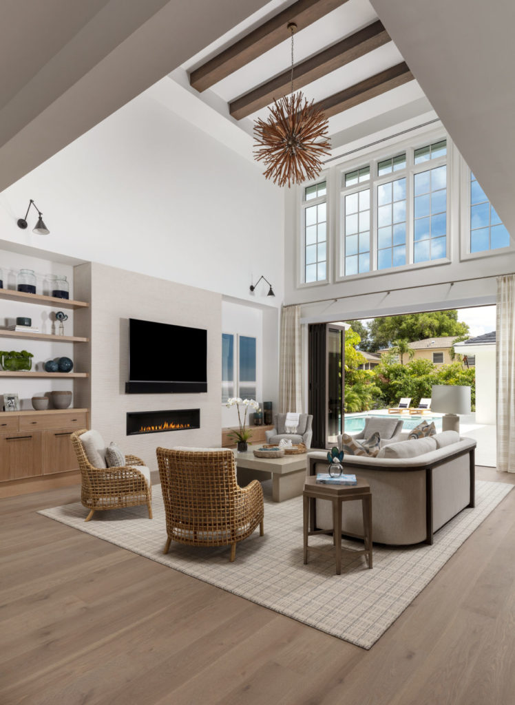 Great room featuring two story windows and sliding doors with neutral interiors