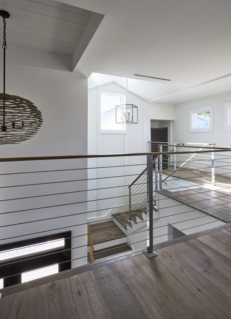 Second floor landing in custom home showing metal railing detail