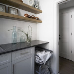 Laundry room with white cabinets and dark countertops and rolling basket Naples Florida